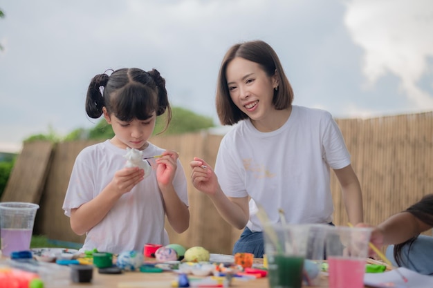 Mother and daughter studying art draw a doll