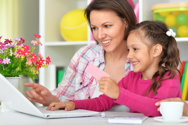 Mother and daughter using laptop together