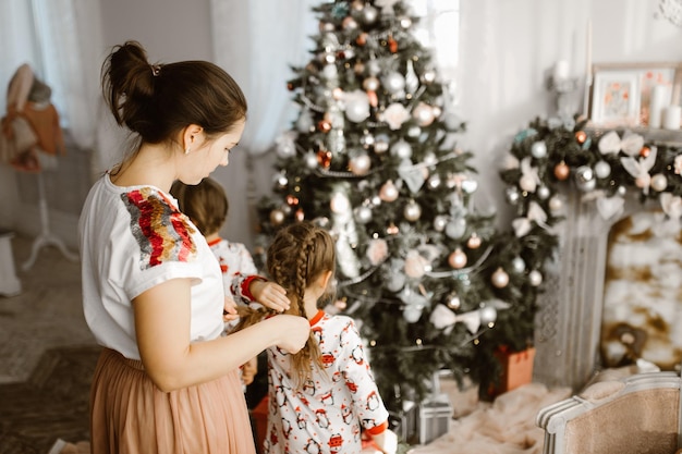 Mother and daughters getting ready for Christmas decorating the tree