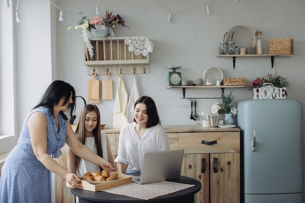 Mother and daughters talking in the kitchen