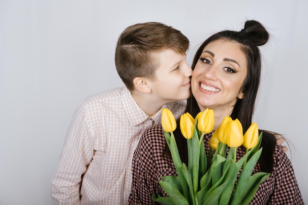 Mother day or birthday happy teenager boy son congratulates mom on holiday birthday