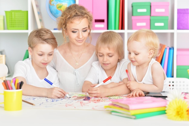 Mother drawing with three cute sons