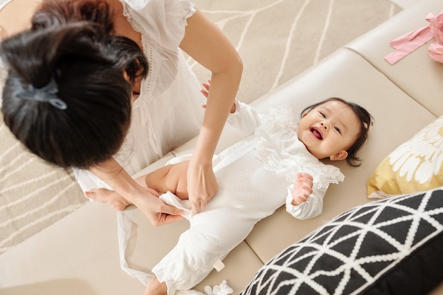 Mother dressing baby girl