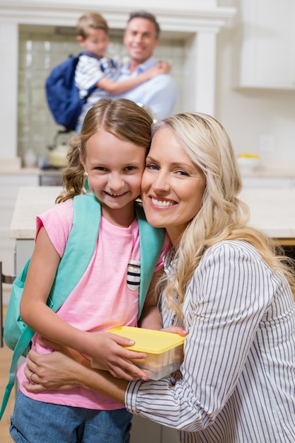 Mother embracing her daughter at home