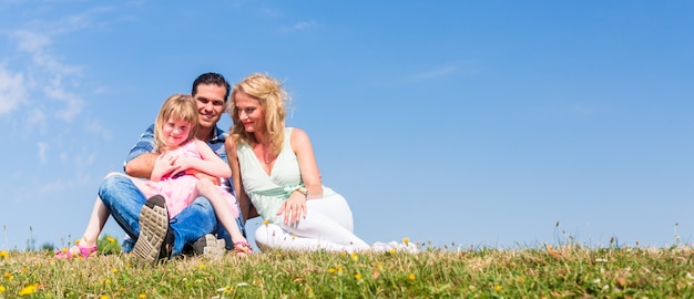 Mother, father, child, sitting in open air