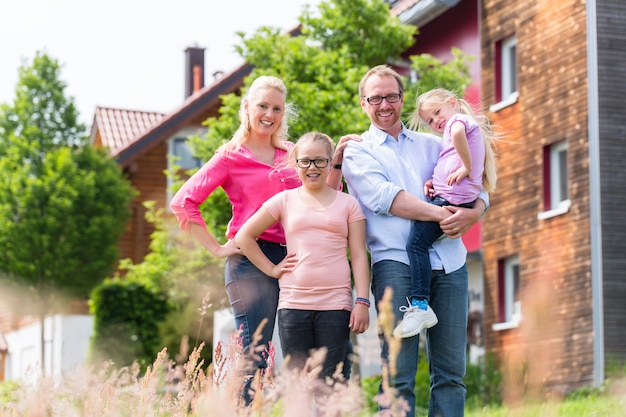 Mother, father and children in front of house