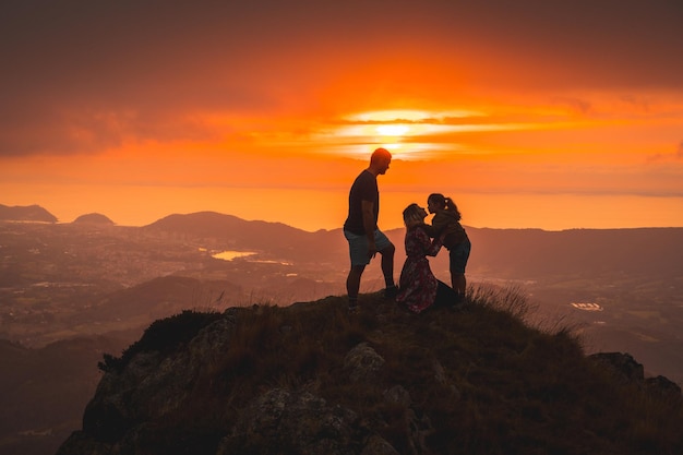 Mother and father next to his son in a beautiful sunset in the mountain