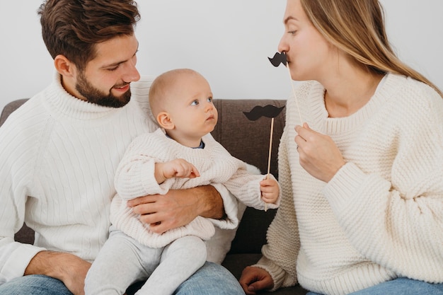 Mother and father playing at home with baby