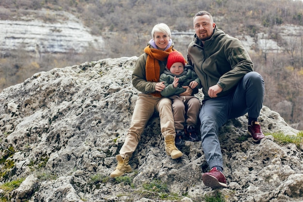 Mother father and son child travel through the caves in warm clothes in the fall