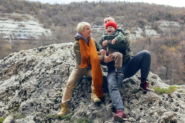 Mother father and son child travel through the caves in warm clothes in the fall