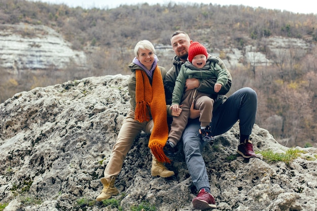 Mother father and son child travel through the caves in warm clothes in the fall