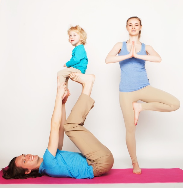 Mother father and son doing yoga over white background