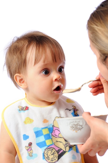 Mother feeds surprised baby from spoon