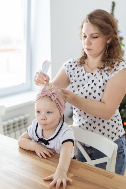 Mother fixing her daughter's cochlear implant hearing aid diversity concept Innovative medical technologies