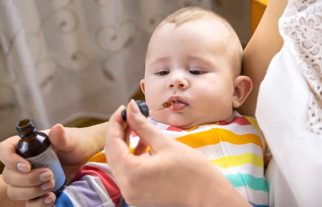 Mother gives colic medicine to little baby Selective focus