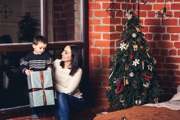 Mother gives gift to her son for Christmas.