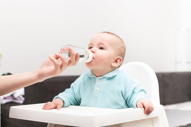 Mother Giving Baby To Drink Water From Bottle