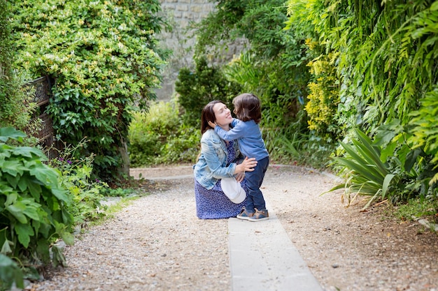 Mother and handsome baby boy walking outdoor in old city park