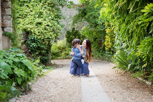 Mother and handsome baby boy walking outdoor in old city park