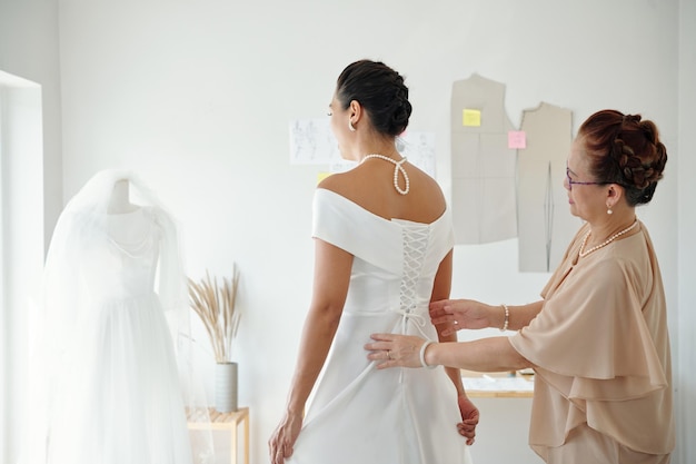 Photo mother helping bride