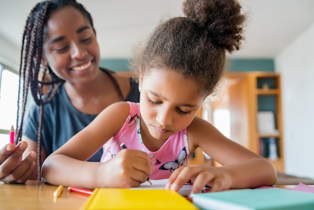 Mother helping and supporting her daughter with homeschool while staying at home