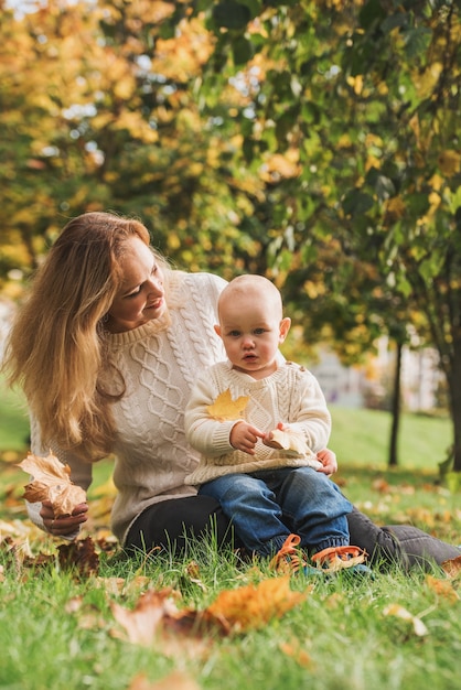 Mother and her baby boy, enjoying the autumn day in park.