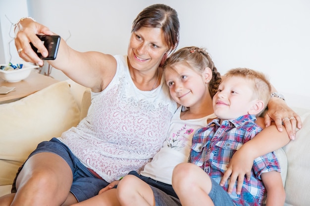 Mother and her children taking a selfie on the sofa.Happy family