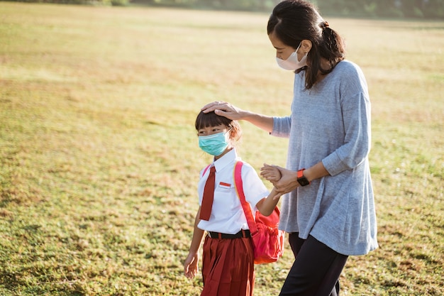 Mother and her daughter walking together and wear face mask