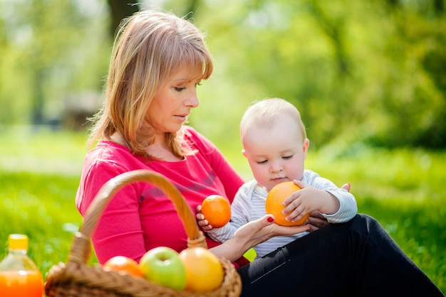 Photo mother and her little son in sunny park