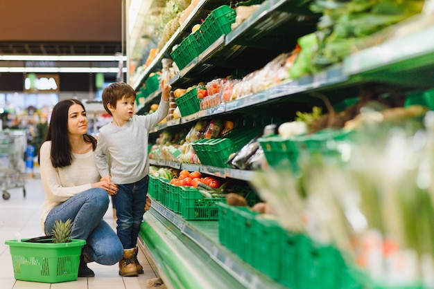 Mother and her son buying fruits at a farmers market