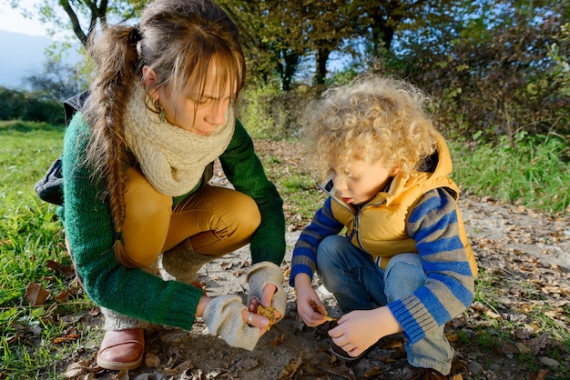 Mother and her son playing with autumn leaves