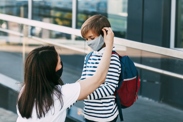 Mother and her son wearing protective masks outdoors