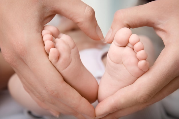 Mother holding baby feet closeup