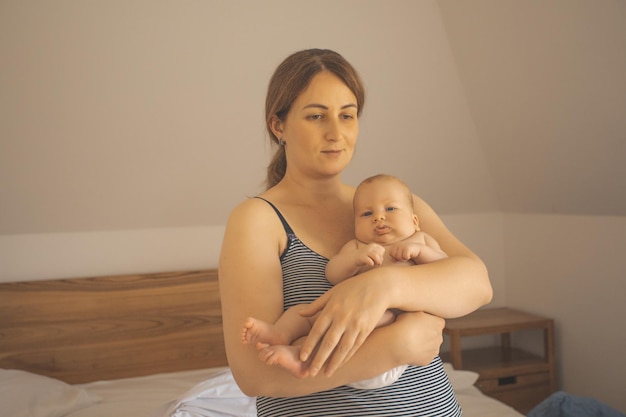 Mother holding baby in the sleeping room