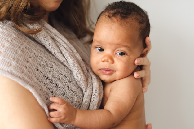 Mother holding cute newborn smiling child.