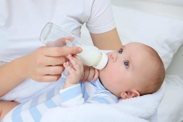 Mother holding and feeding baby from bottle