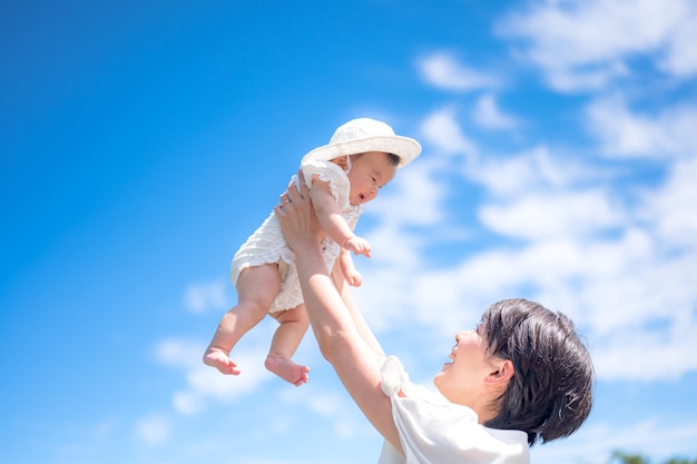 A mother holding her baby up in the sky