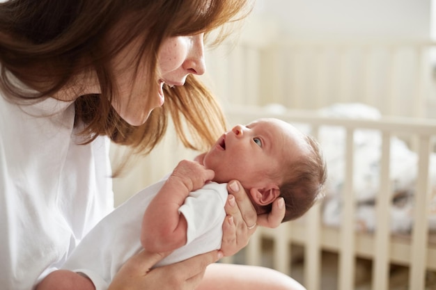 Mother holding her newborn baby Home portrait of newborn baby and mother Enjoying time together