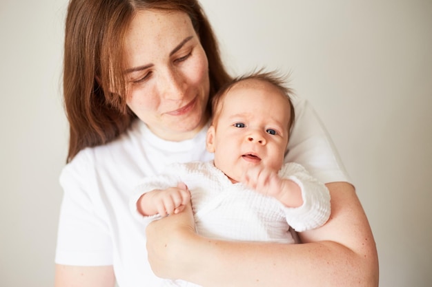 Mother holding her newborn baby Home portrait of newborn baby and mother Enjoying time together