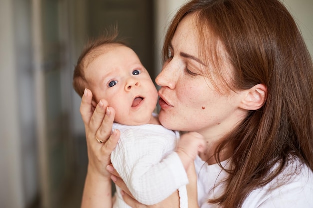 Mother holding her newborn baby Home portrait of newborn baby and mother Enjoying time together