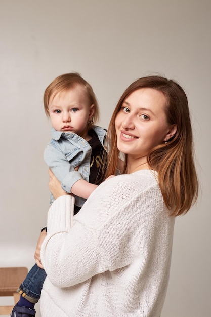 Mother holding her son Woman and boy relax and playing on white background Family maternity tenderness parenthood responsibility concept Banner