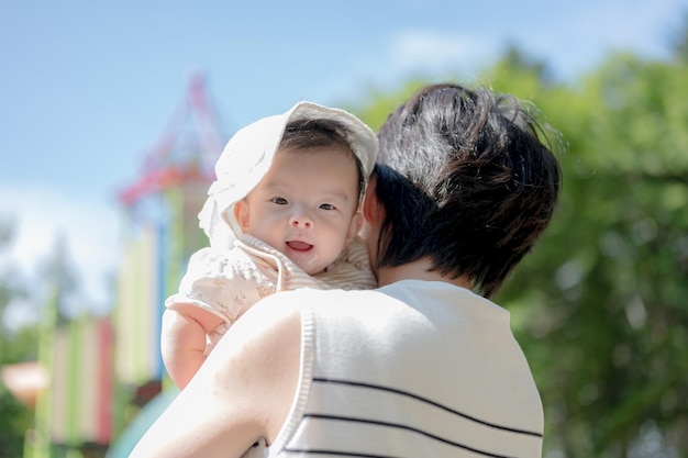 A mother holds her baby in her arms.