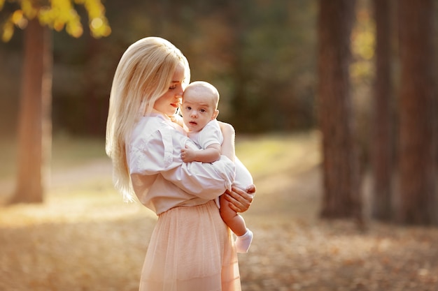 mother hugging her baby autumn landscape walk in nature outdoors family motherhood parenting