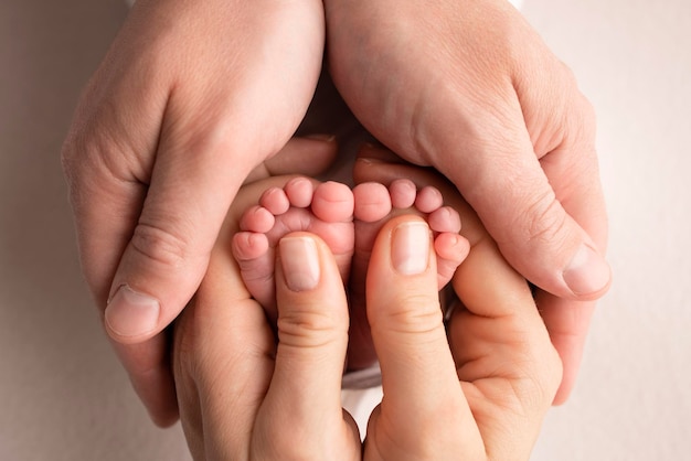 Mother is doing massage on her baby foot Closeup baby feet in mother hands Prevention of flat feet development muscle tone dysplasia Family love care and health concepts Studio macro