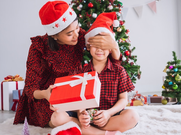 Mother is surprised son by closing eyes  with gift box