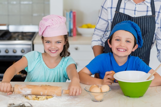 Mother and kids preparing food in kitchen