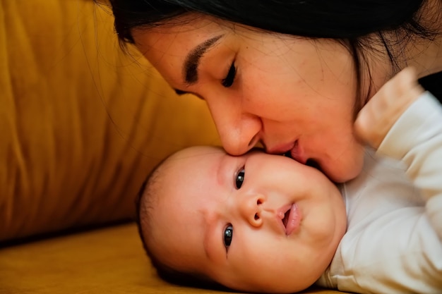 Mother kisses the cheek of a newborn the concept of a kiss motherly love