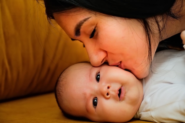 Mother kisses the cheek of a newborn the concept of a kiss motherly love