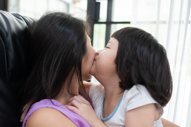 Mother kisses her daughter's cheeks