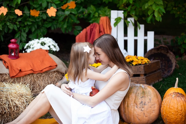 Mother kissing her child in autumn background